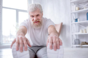 older man exercising stretching yoga medical instructions